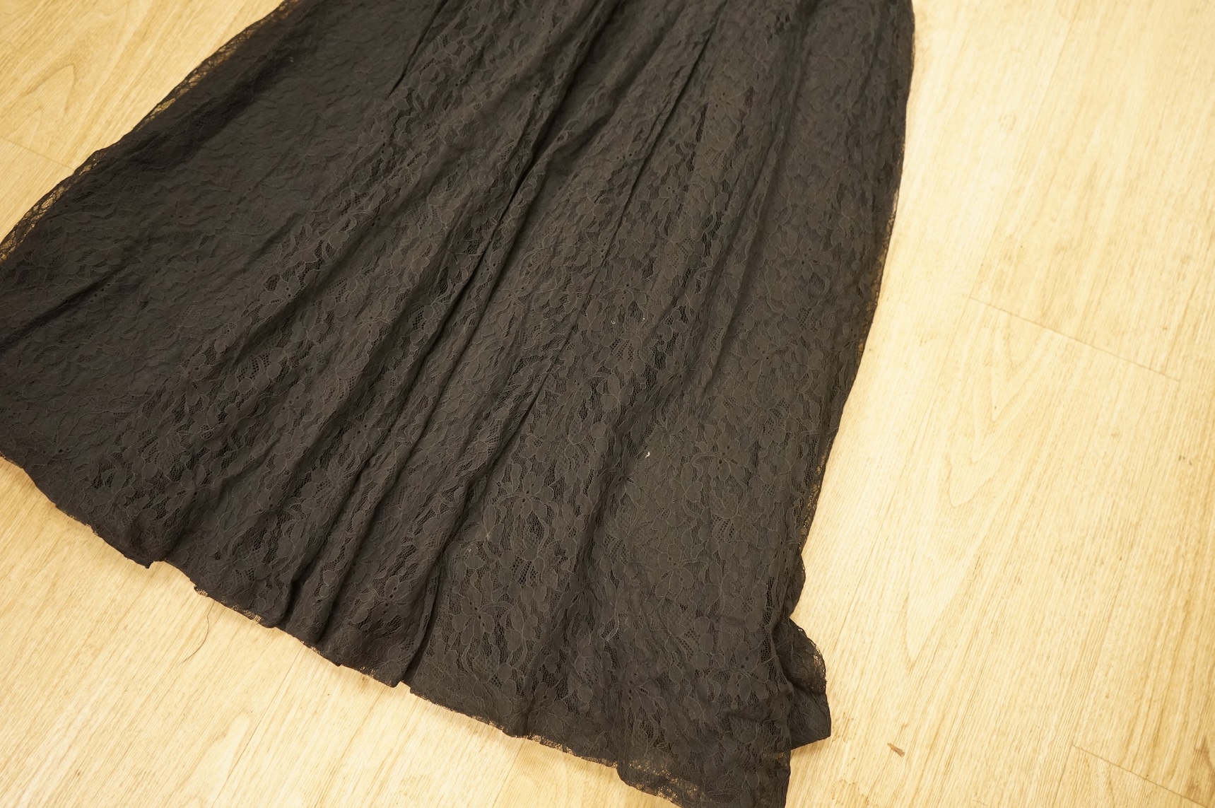 A late 1940’s black lace evening dress, a similar evening dress with black velvet ribbon detail, a maroon brocade halter neck evening dress and a dark mustard early 1950’s evening silk duster coat.